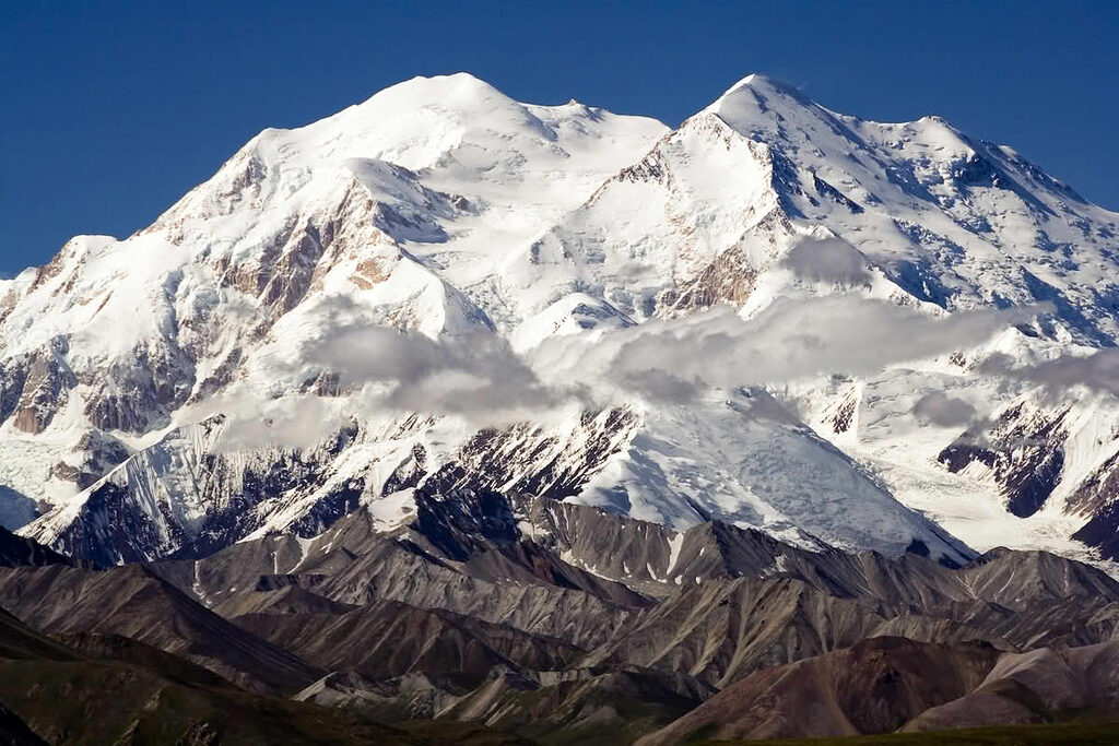 Núi Denali phủ đầy tuyết dưới ánh sáng lạnh, đỉnh núi chìm trong gió mạnh và sương mù băng giá ở Alaska